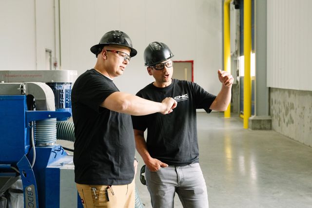 Jovan and Vince Covollo pointing and discussing work on a current CNC jobsite