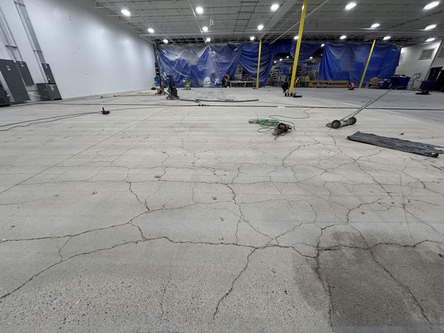 Before: cracked concrete floor near the active work area, staged for prep